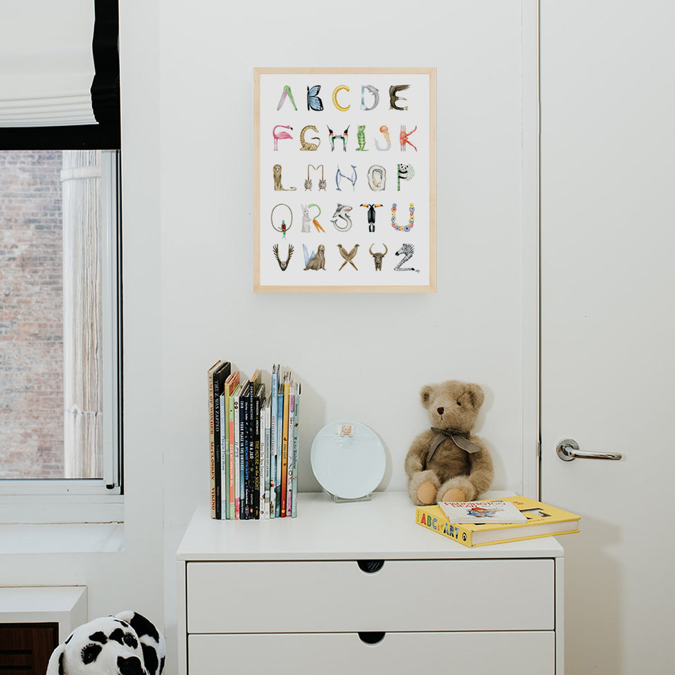 The Letter Nest Animal Alphabet in a Natural Frame hanging in a nursery