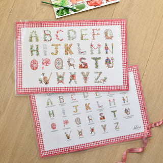 Flatlay photo of The Letter Nest's Advent Alphabet placemats with red gingham border showing front and back 
