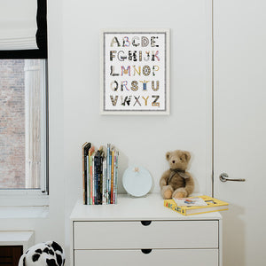 Chess Alphabet with Black Gingham Border and White Frame hanging in a nursery