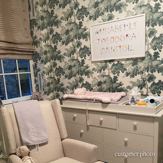 Customer Photo with Full Name Print in Flower letters spelling "Annabelle Theodora Bristol" in a white frame against an elegent tree-filled wallpaper