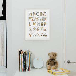 Musical Instruments Alphabet Print by The Letter Nest in a white frame installed in a nursery