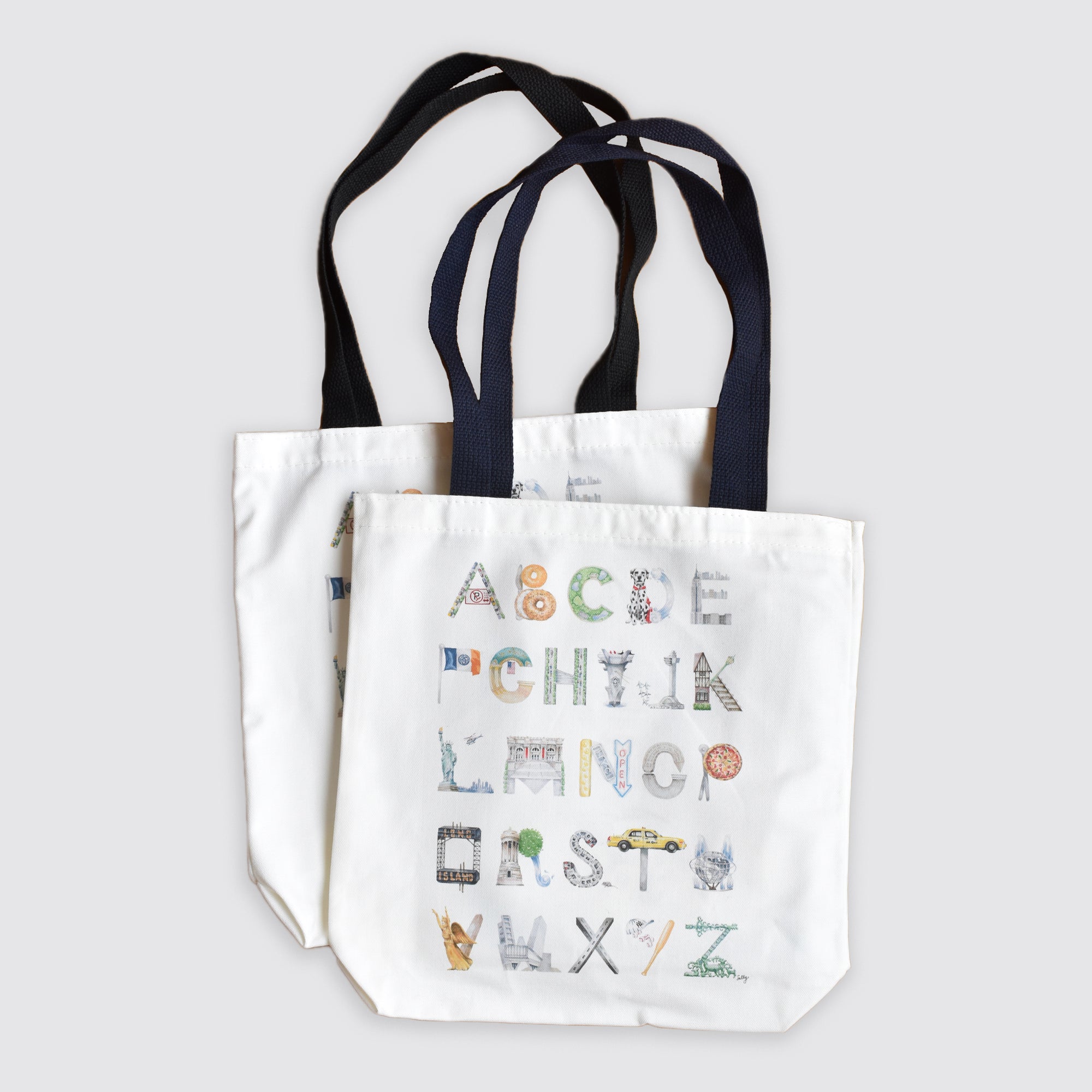 Product flat lay photo of the NYC Alphabet Tote: Black in black, navy in foreground