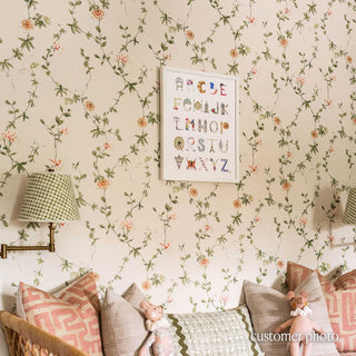 Nursery with Sanderson floral wallpaper with The Letter Nest's Paris Alphabet in a white frame, installed among a beautiful daybed styled with pink and green pillows and wall sconces