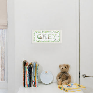 Woodland Custom Name Print in white frame in the name "Grey" with a painted vine border hung up in a nursery
