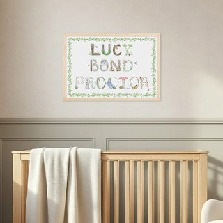 Nursery room with wooden crib, rocking chair, and framed Full Name Print by The Letter Nest in Woodland theme letters with vine border in a natural frame.