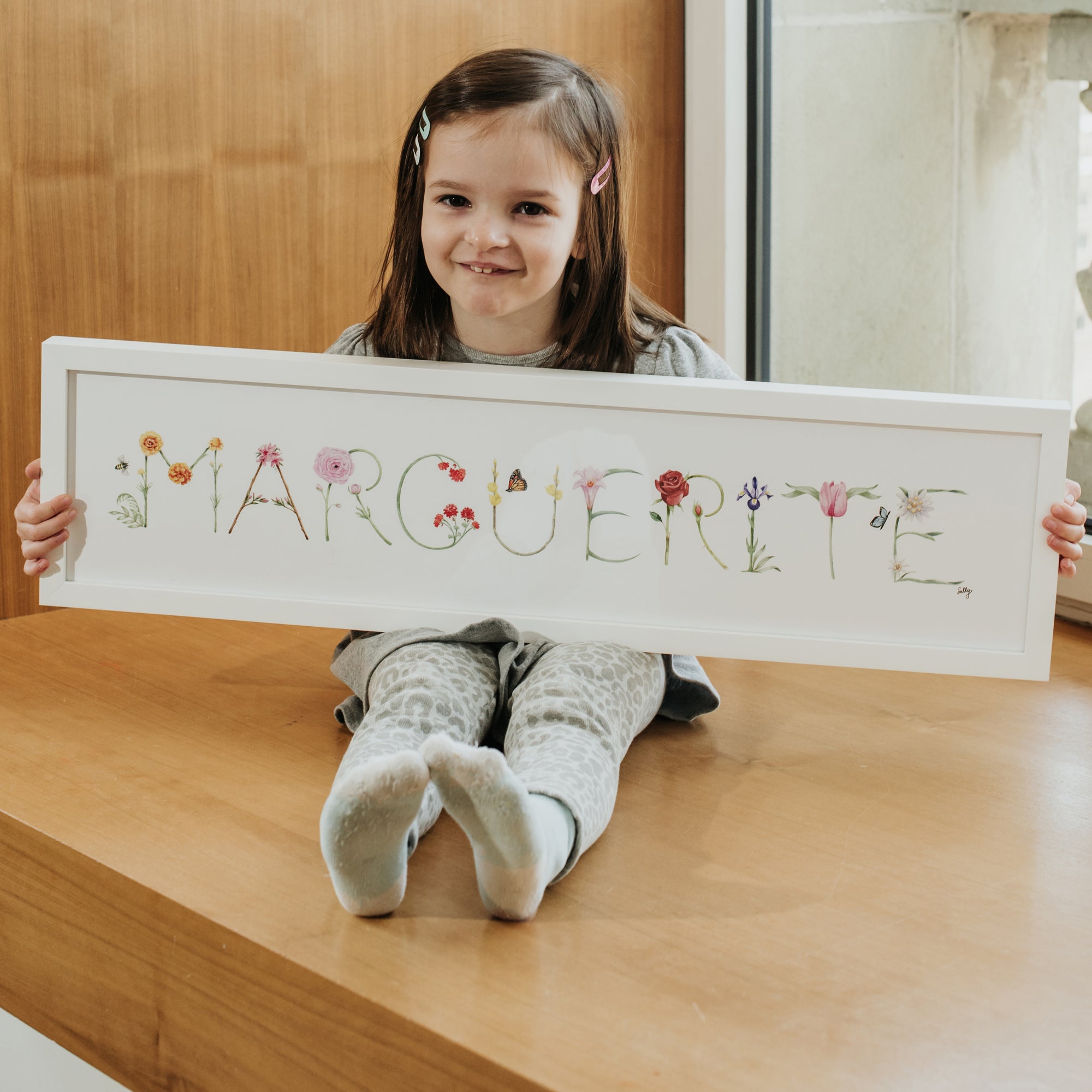 Marguerite holding her Custom Flower Name Print by The Letter Nest