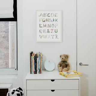 Woodland Alphabet in a White Frame from The Letter Nest, shown in a children's nursery