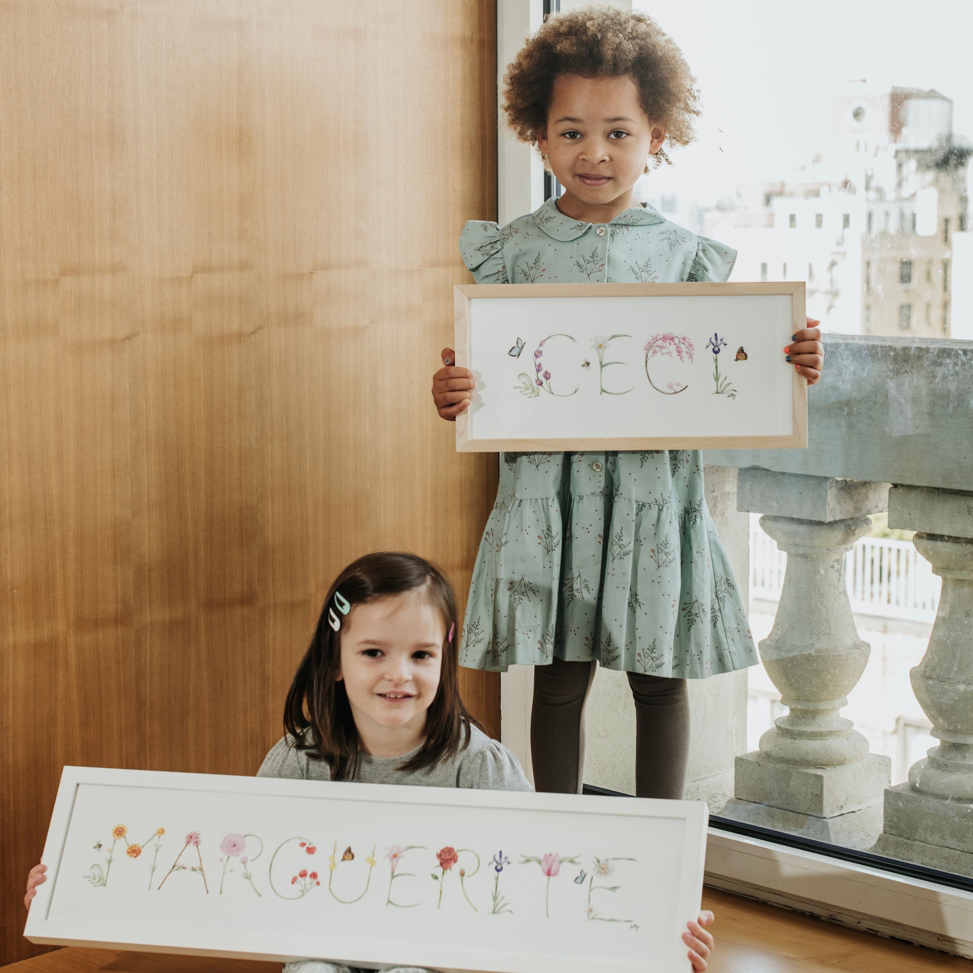 Ceci and Marguerite holding their Flower Name Prints by The Letter Nest