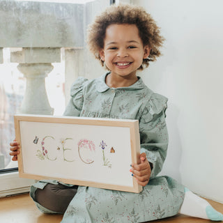 Ceci holding her Custom Flower Name Print by The Letter Nest